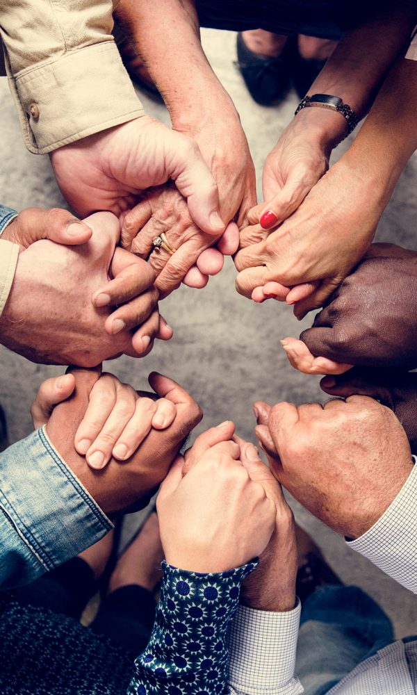 Group of diverse hands holding each other support together teamwork aerial view